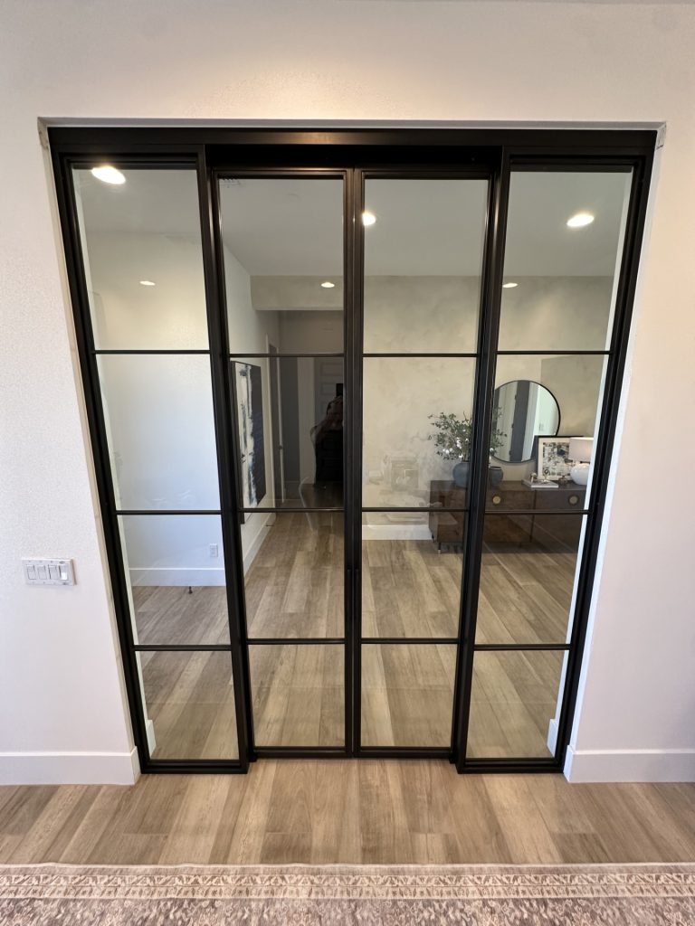 Black metal and glass sliding doors and sidelights with a concealed upper track