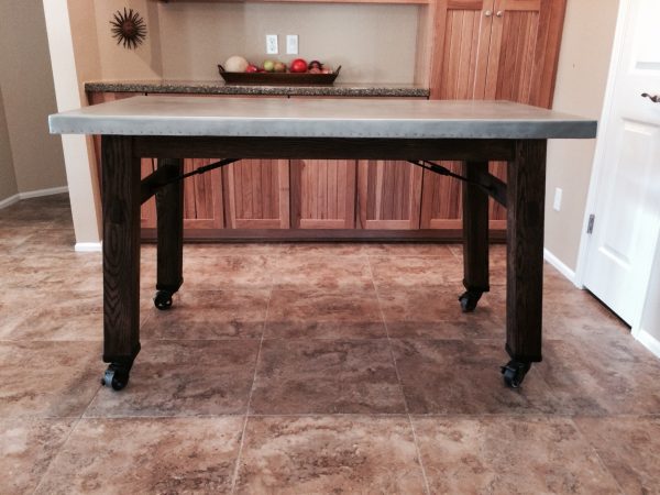 Zinc topped table with dark wood legs on casters
