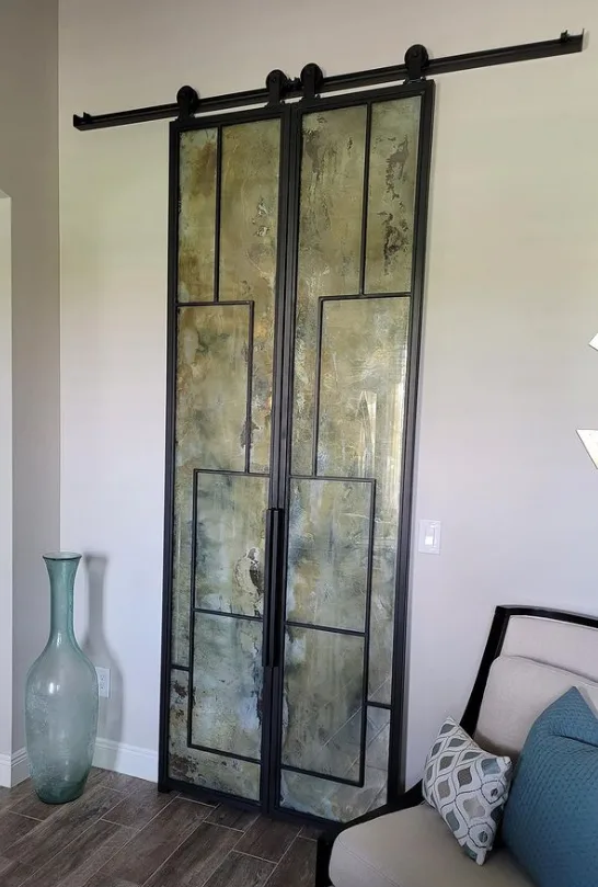 Random pattern antique mirror double sliding barn doors.
