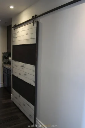 ranch style barn door with wire mesh and white weathered paint