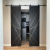 Pair of black stained white oak sliding barn doors with diagonal brass inlays opening to a walk in closet