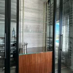 Brass Bistro with Glass Shelves Above a Walnut Cabinet