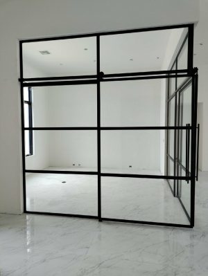 Corner Metal and Glass Barn Doors Corner black metal and glass enclosure with sliding barn doors and transoms
