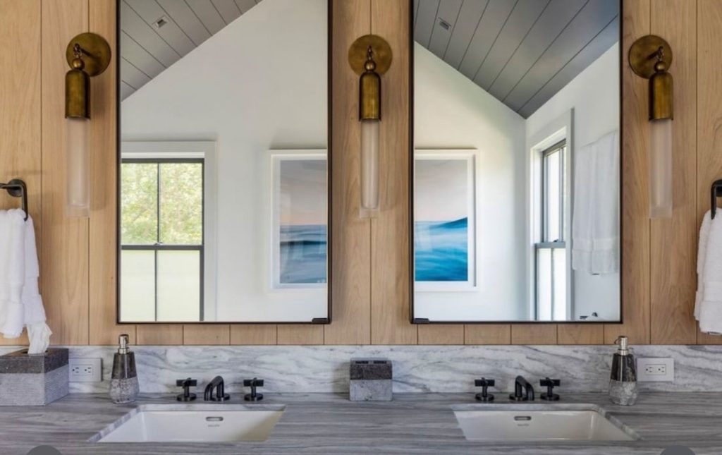 Double vanity mirrors with black metal frames above two sinks