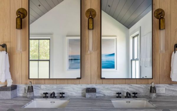 Double vanity mirrors with black metal frames above two sinks