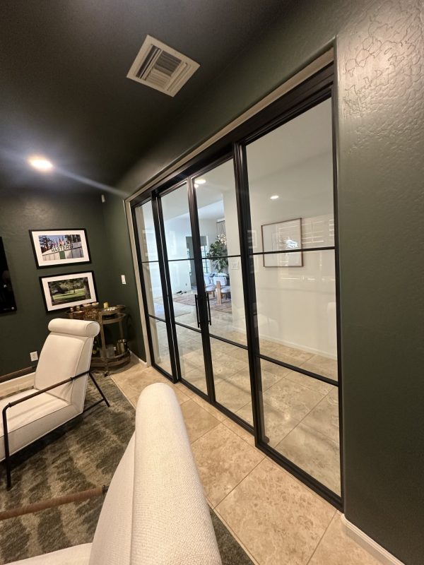 Black metal and glass double sliding doors and sidelights with a concealed track