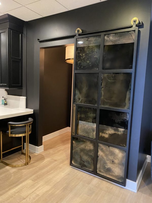 8 Pane Antiqued Barn Door Eight pane antiqued mirror barn door at a bathroom entry