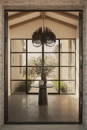 Tall black steel and glass double entry doors opening to a dining area