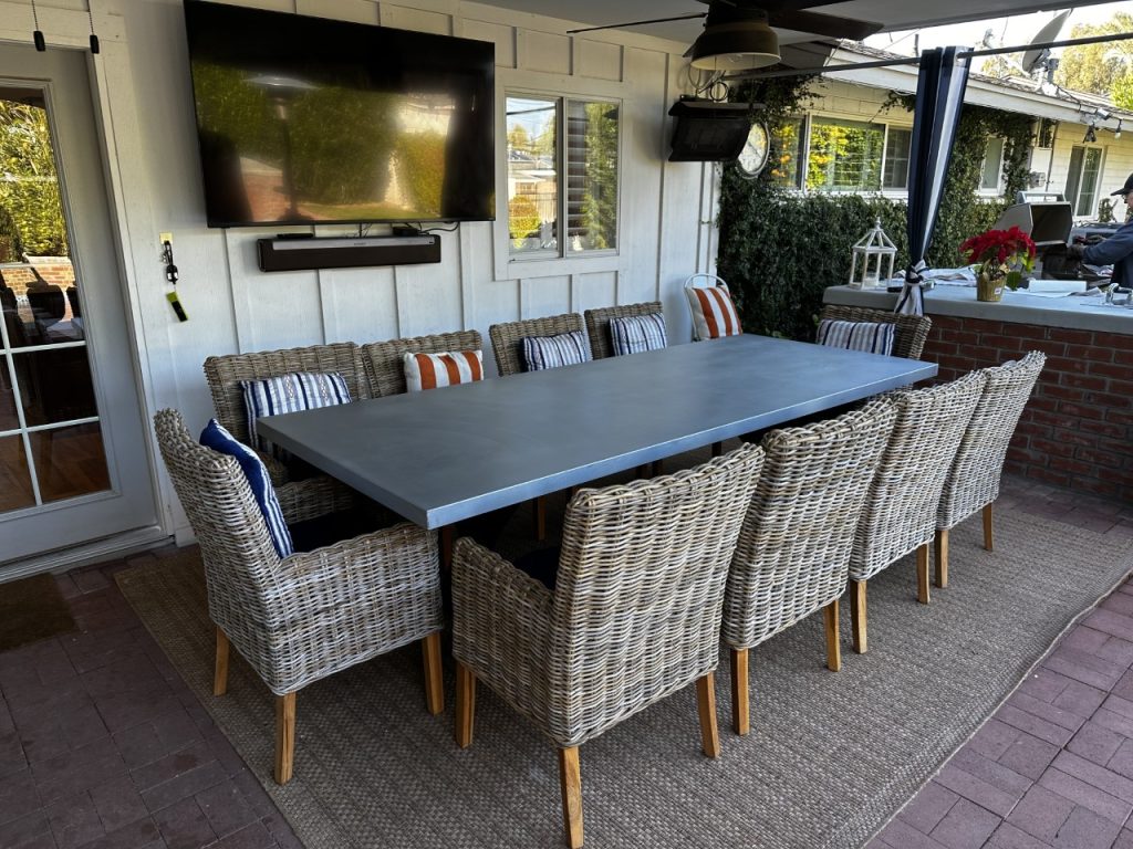 Long zinc top patio dining table with woven chairs