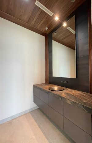 Frameless Mirror Backlit frameless mirror above a floating wood vanity