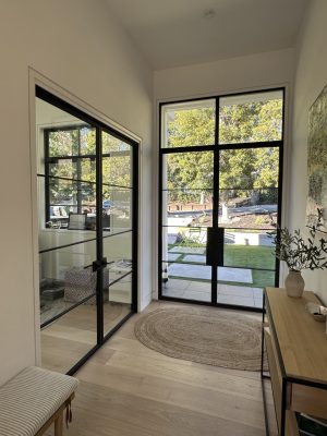 Black metal and glass double front entry doors in a bright entryway