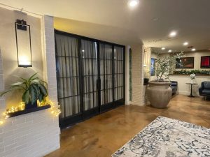 Black metal and glass doors and sidelights in a hotel lobby with white brick walls