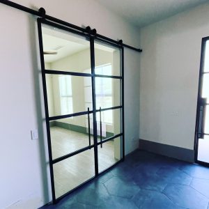 Steel and Clear Glass Barn Doors Black steel and clear glass grid barn door on an exposed track