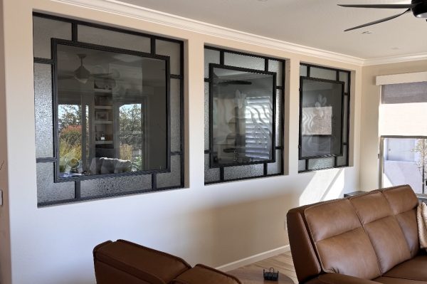 Interior Metal and Specialty Glass Windows Three black metal interior windows with specialty glass in a living room wall