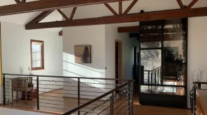 Large Random Pattern Antique Mirror and Metal Barn Door Large random pattern antique mirror and metal barn door in an open loft with a railing
