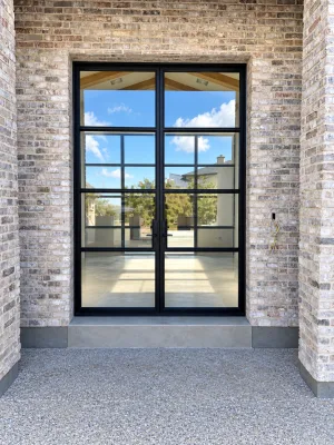 Black metal and glass double front doors set in a brick entry