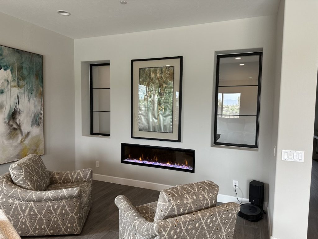 Black metal and glass interior windows on either side of artwork above a fireplace