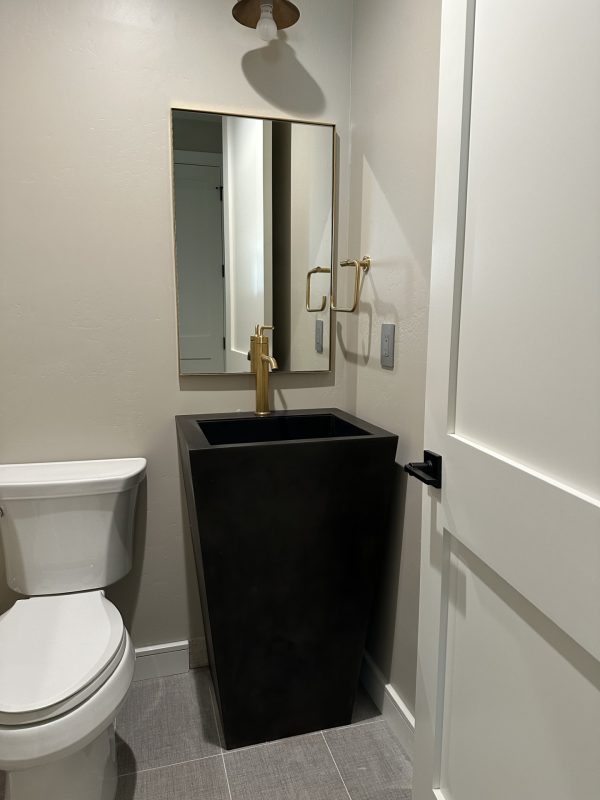 Black metal free standing pedestal sink in a powder room