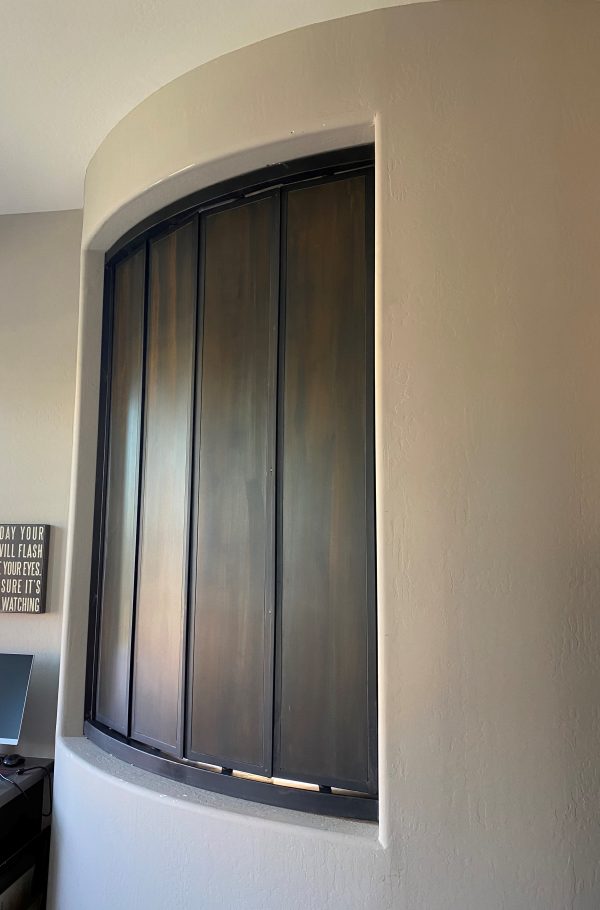 Curved metal louver window set into a rounded wall