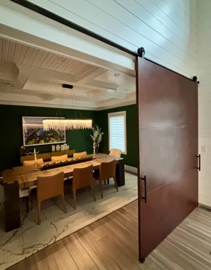 Oversized Patina Metal Panel Barn Door Oversized rust toned patina metal panel barn door sliding open to a dining room with green walls