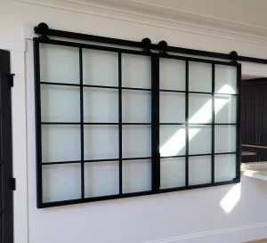 Kitchen Pass Through Doors Black metal and frosted glass sliding pass through doors over a kitchen opening