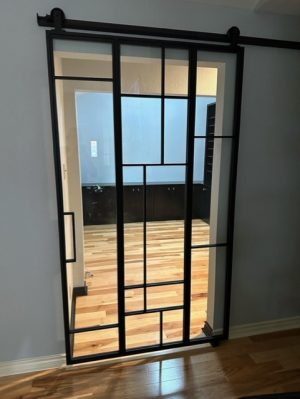 Random Metal and Glass Barn Door Black metal barn door with random pattern clear glass panels