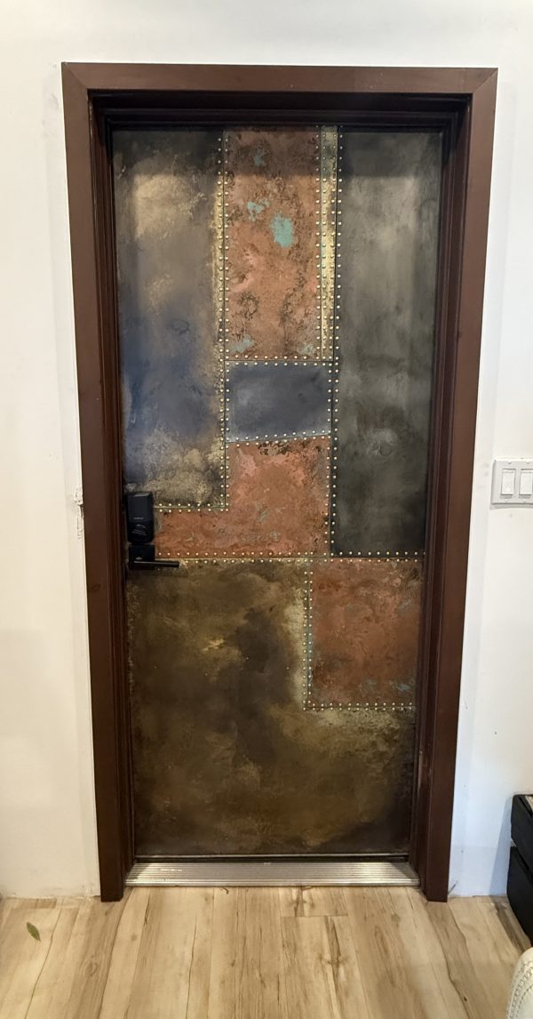 Patinaed copper, brass and zinc riveted patchwork front entry door in Tampa, Florida