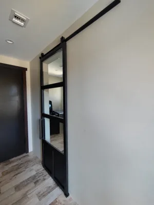Single Industrial Contemporary Metal and Glass Barn Door Narrow single black metal and glass barn door with a solid lower panel