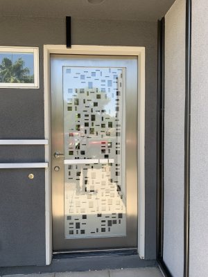 Stainless steel and glass front door with a CNC cut random pattern