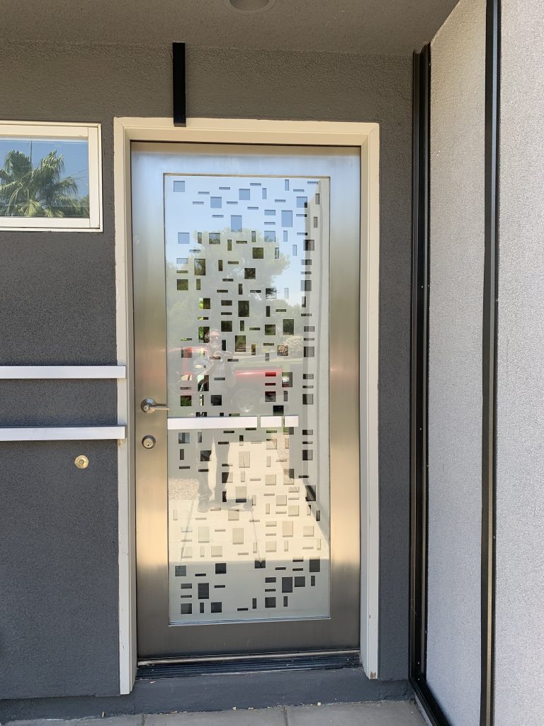 Stainless steel and glass front door with a CNC cut random pattern