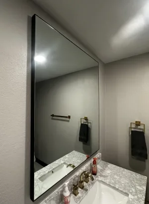 Thin Metal Framed Mirror Thin black metal framed mirror above a bathroom vanity