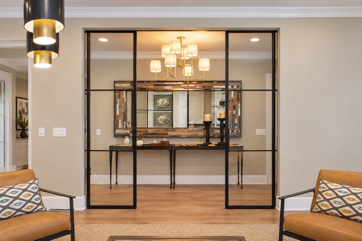 Thin frame metal and glass sliding barn doors with side panels in a hallway