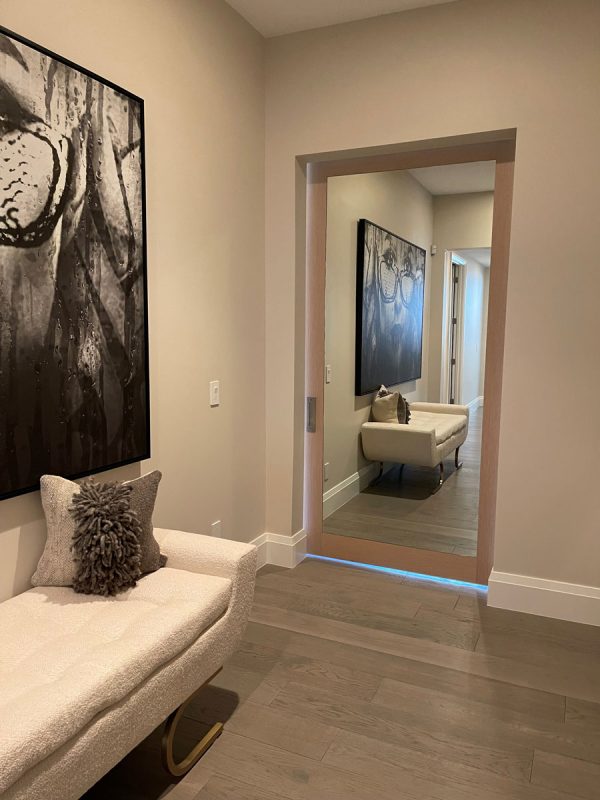 Wood veneer barn door with a mirror inset in a hallway