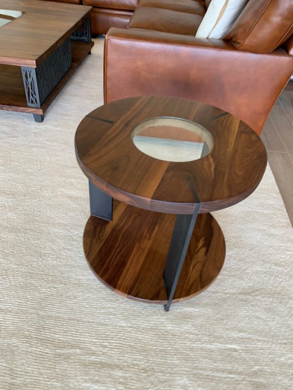 Walnut Side Table Round walnut side table with a glass inset and metal frame beside a leather chair