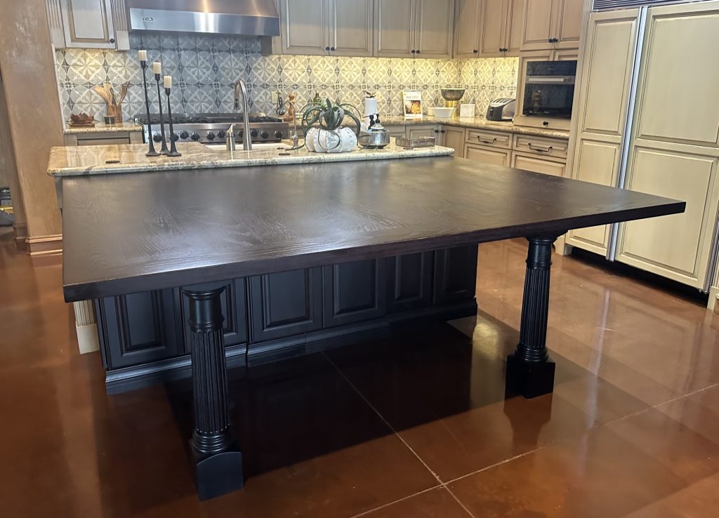 Large dark wood dining table extending from a kitchen island