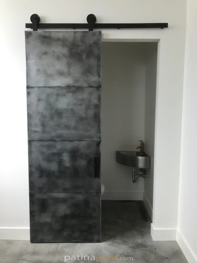 pure zinc panel barn door with an antique black patina finish